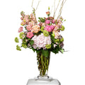 Pristine arrangement of blush roses, lisianthus and viburnum in a tall glass vase