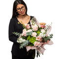 Nature's Smile bouquet of blush roses, green hydrangea and eucalyptus, held by a florist