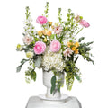 Monaco arrangement of pink roses, stock, hydrangea and ranunculus in a white footed vase