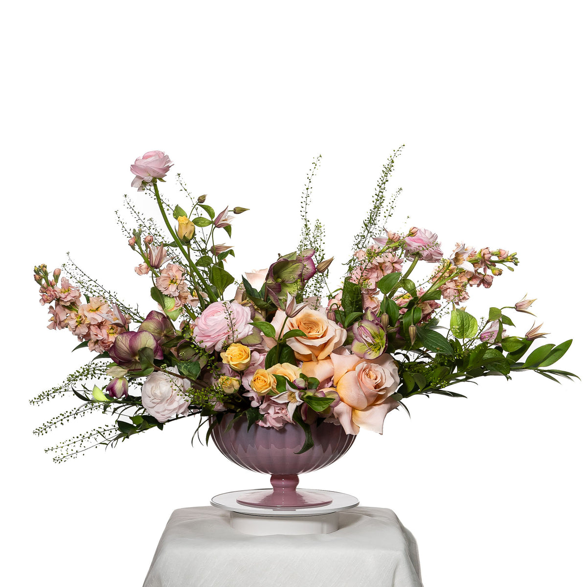 Kandi arrangement of peach roses, snapdragons and grasses in a mauve footed bowl