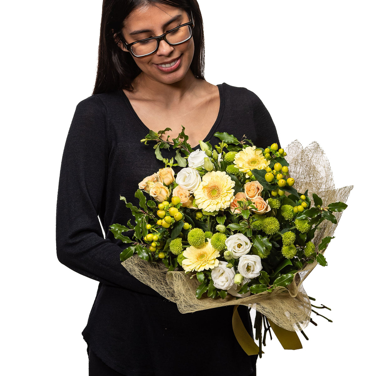 Harmony bouquet of cream roses, yellow blooms and greenery, held by a florist