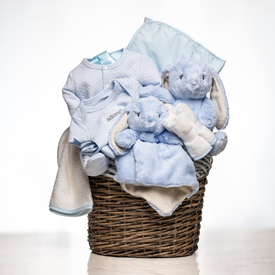 Hoppy Hamper baby boy gift in a woven basket with a blue blanket, a plush bunny and a comforter