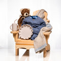 Muskoka Bear baby boy gift, a wooden chair with a teddy, a navy knitted set and a sippy cup