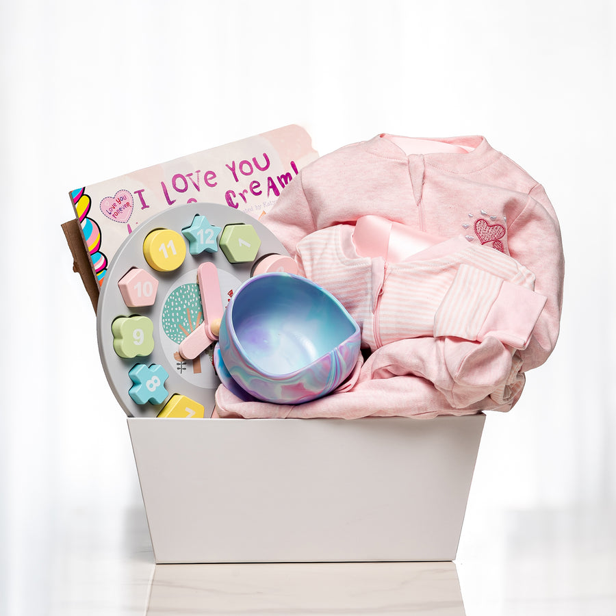 Dream and Discover baby girl gift with pink knitwear, a bowl, teethers and an I Love You card