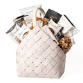 Bountiful Bundle Small: a white washed woven carrier with a handle, filled with biscotti, pistachios, peanuts, French truffles, pretzels, brittle and gourmet snacks