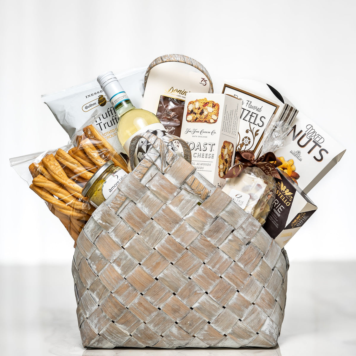 Bountiful Bundle woven grey basket with breadsticks, nuts, cookies, chocolates and white wine