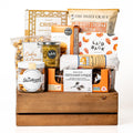 Canadian Cravings: a brown slotted wood crate with a jar of shortbread cookies, Raincoast Crisps, Laid Back snack mix, lentil chips, olive tapenade and caramel popcorn