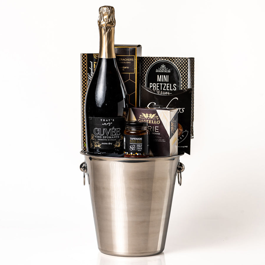 Celebration gift: a stainless steel ice bucket holding a bottle of That's Amore Cuvée Spumante with Castello brie, black olive tapenade and mini pretzels