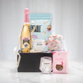 Cheers to You gift set with sparkling wine, a stemless glass and cookie pops on a black riser