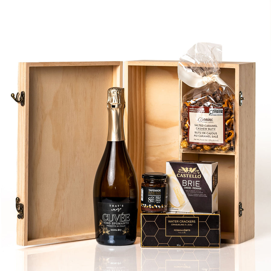 Congratulations Box: a hinged wooden celebration box with dividers holding a bottle of That's Amore Cuvée Spumante, Castello brie, tapenade, water crackers and caramel cashew popcorn