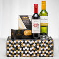 Double Wine Tasting gift with a bottle of red and a bottle of white wine, brie and crackers on a patterned box