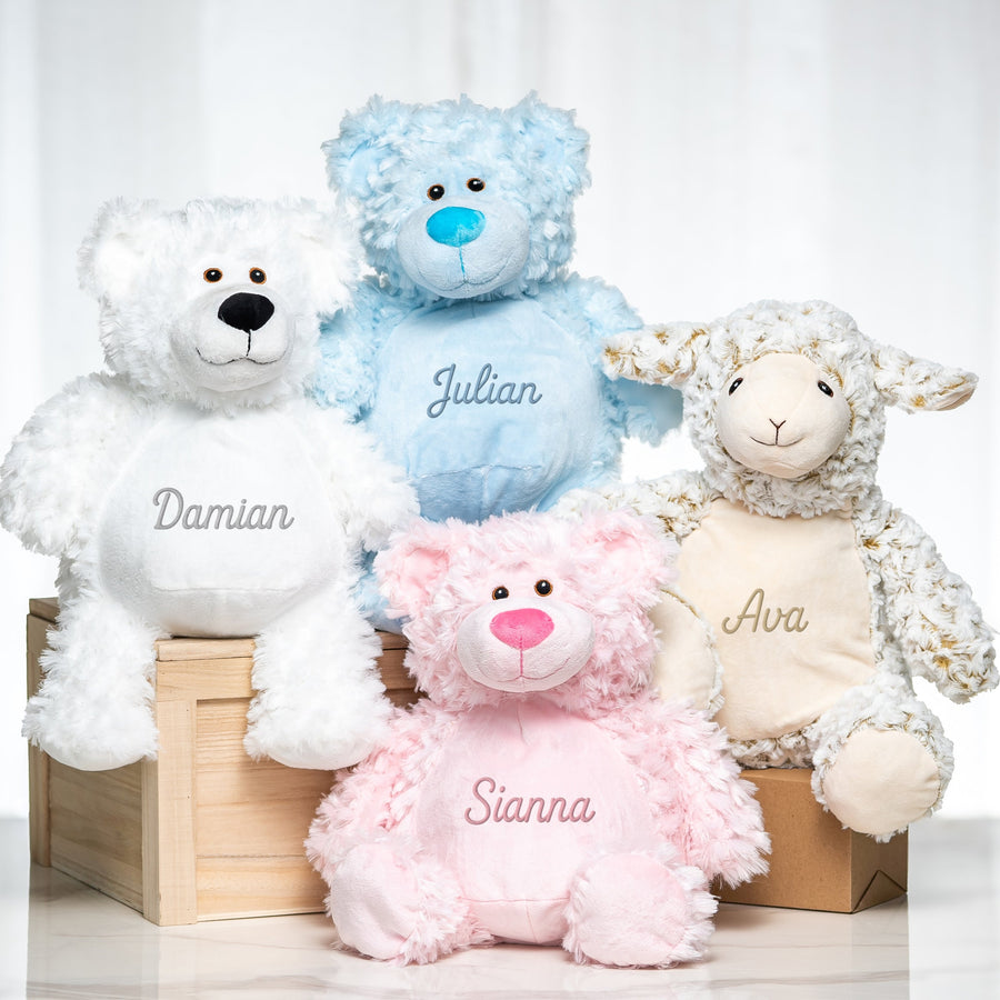 Four personalised plush toys, white and blue teddy bears, a pink bear and a cream lamb, each embroidered with a name