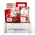 Festive Faves Medium: a white washed wood crate with Lindt Lindor truffles, Pirouline wafer rolls, salted pretzels, cranberry almond biscotti, a Donini bar and maple buttercrunch bark