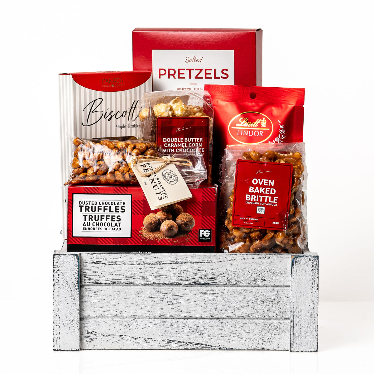 Festive Faves Small: a white washed wood crate with Lindt Lindor truffles, salted pretzels, biscotti, double butter kettle corn, oven baked brittle and chocolate truffles