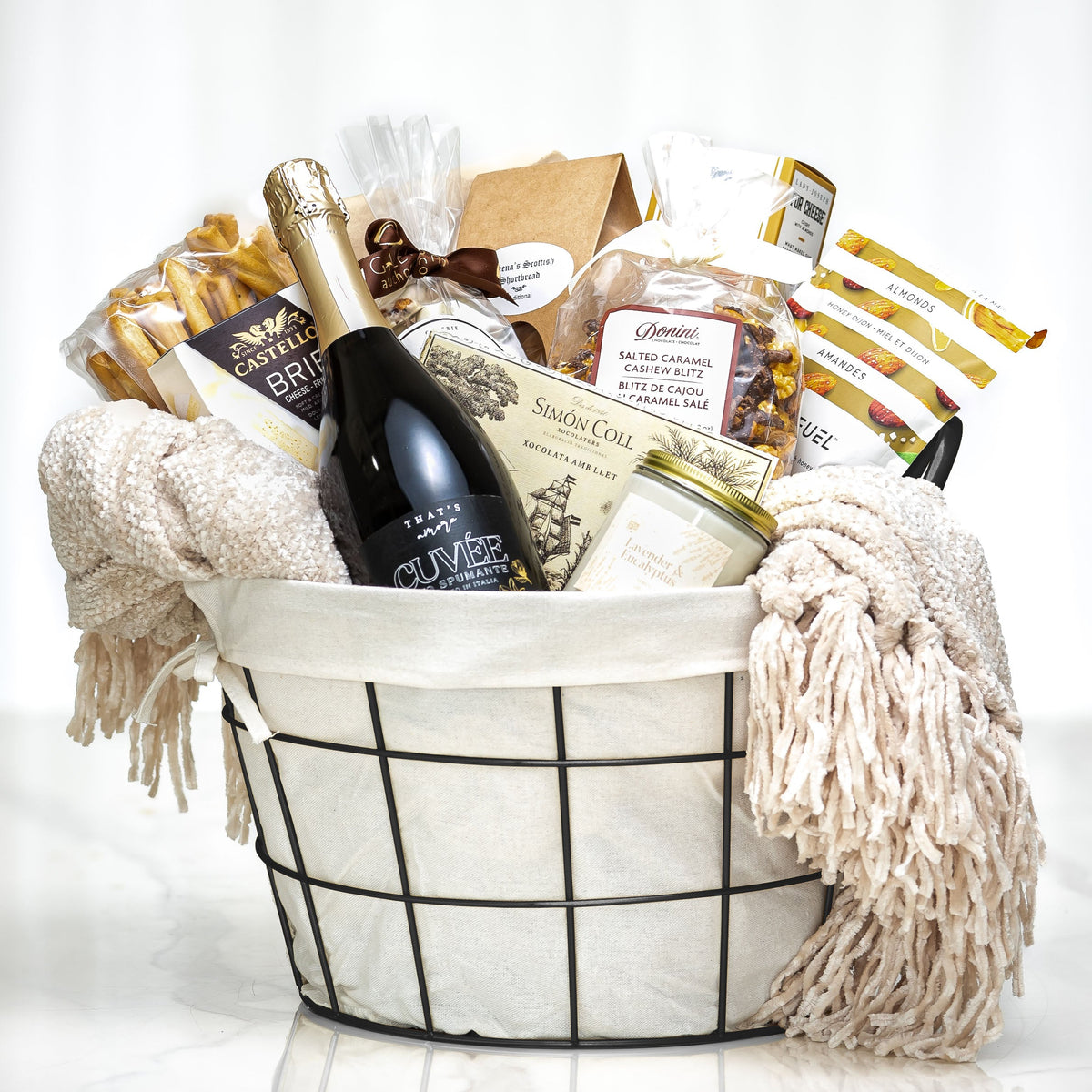 Fireside Favourites gift basket with a bottle of wine, chocolates and a cream throw blanket