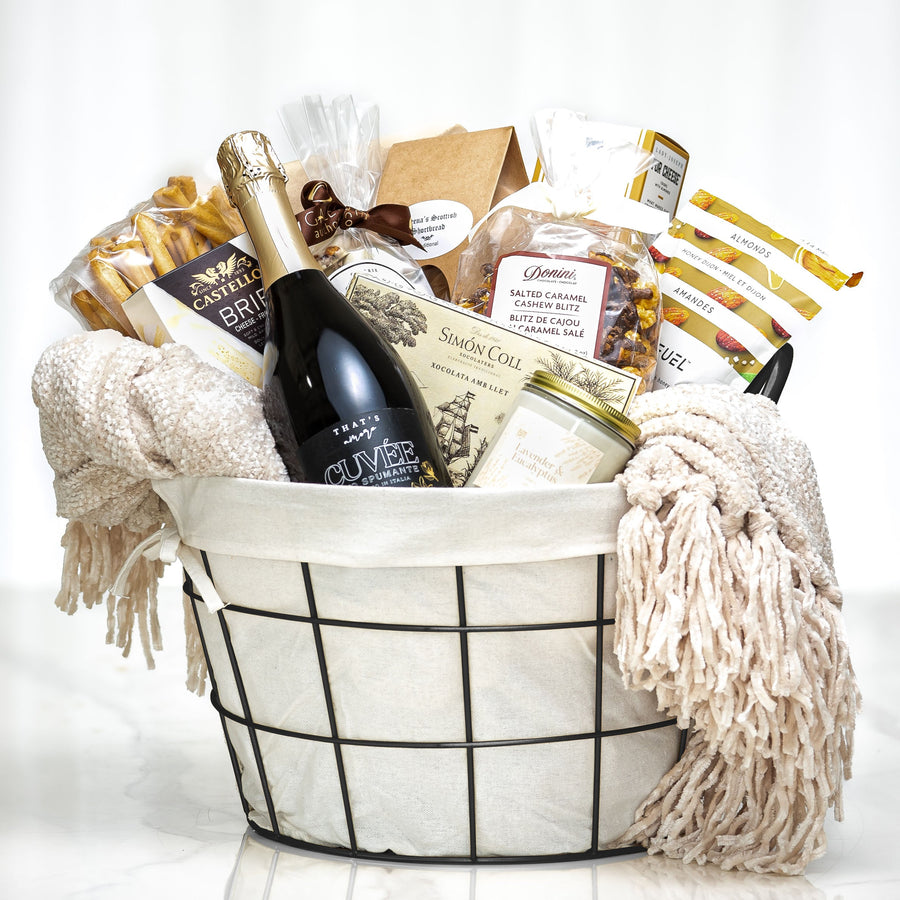 Fireside Favourites gift basket with a bottle of wine, chocolates and a cream throw blanket