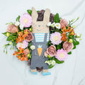 Flourishing Fussenegger bunny plush toy surrounded by a wreath of peach and pink blooms