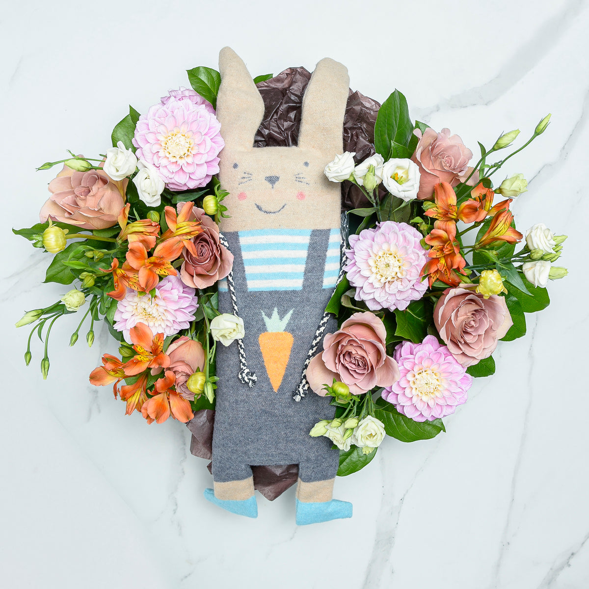 Flourishing Fussenegger bunny plush toy surrounded by a wreath of peach and pink blooms