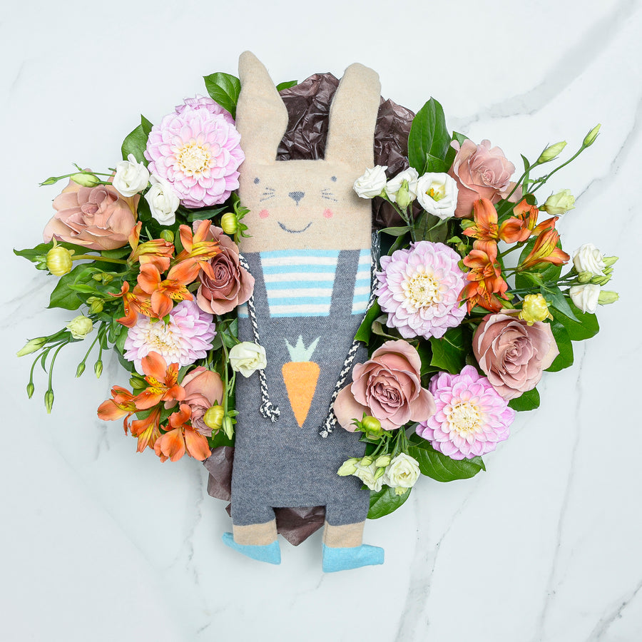 Flourishing Fussenegger bunny plush toy surrounded by a wreath of peach and pink blooms