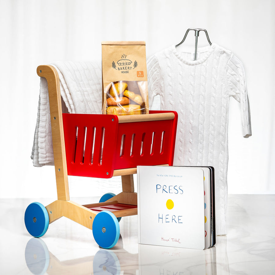 Fresh Finds baby gift with a wooden toy shopping trolley, a knitted outfit and the book Press Here