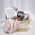 Girl On The Go gift with a cream toiletry bag, a mirror, scrunchies, clips and travel bottles