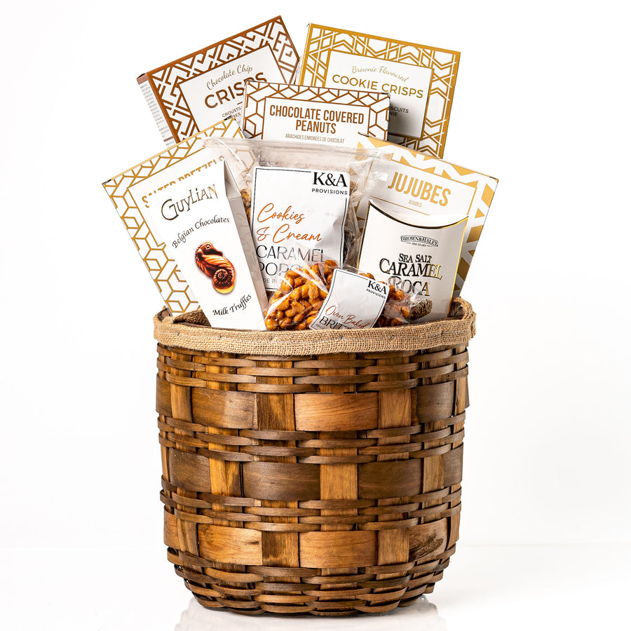 Hearty Hamper Small: a round woven wood chip hamper filled with cookie crisps, jujubes, salted pretzels, chocolate covered peanuts, caramel popcorn and Guylian truffles