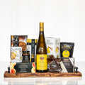 Hostess gift board with brie, nuts, crackers, chocolates and a bottle of white wine