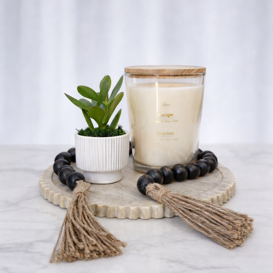 Luxe Living gift with a large candle, a potted succulent and wooden bead garlands on a tray