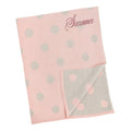 Pink knitted baby blanket with grey polka dots, personalised with the embroidered name Sianna
