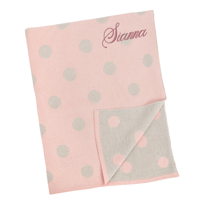 Pink knitted baby blanket with grey polka dots, personalised with the embroidered name Sianna