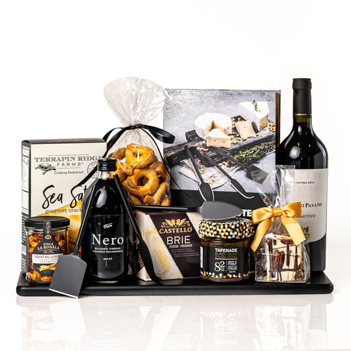 Nero gift: a black serving board with a bottle of Poggio Pasano Primitivo, Nero balsamic vinegar, Castello brie, Terrapin Ridge crackers, cocktail nuts, tapenade and black cheese knives