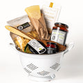 Pasta Pomodoro: a colander filled with Cucina & Amore farfalle, tomato and basil pasta sauce, basil pesto, a Parmigiano wedge, sesame grissini, pepperoncino and a wooden spatula