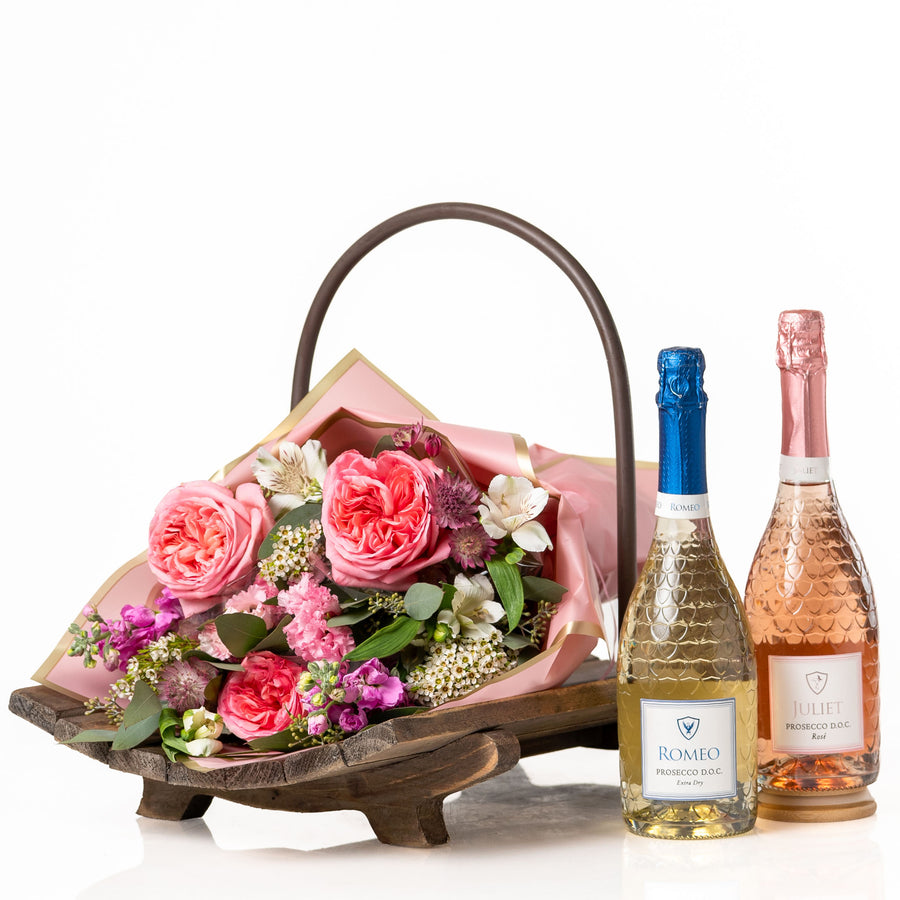 Petals & Prosecco: a curved wooden tray with a metal handle holding a bouquet of pink garden roses and alstroemeria beside bottles of Romeo and Juliet Prosecco