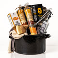 Pot of Plenty: a black enamel stock pot holding layered soup mixes, roasted chicken bone broth, a stainless steel ladle, an oil and vinegar bottle, knit tea towels, a felt ball trivet, cheese crisps and a Parmigiano wedge