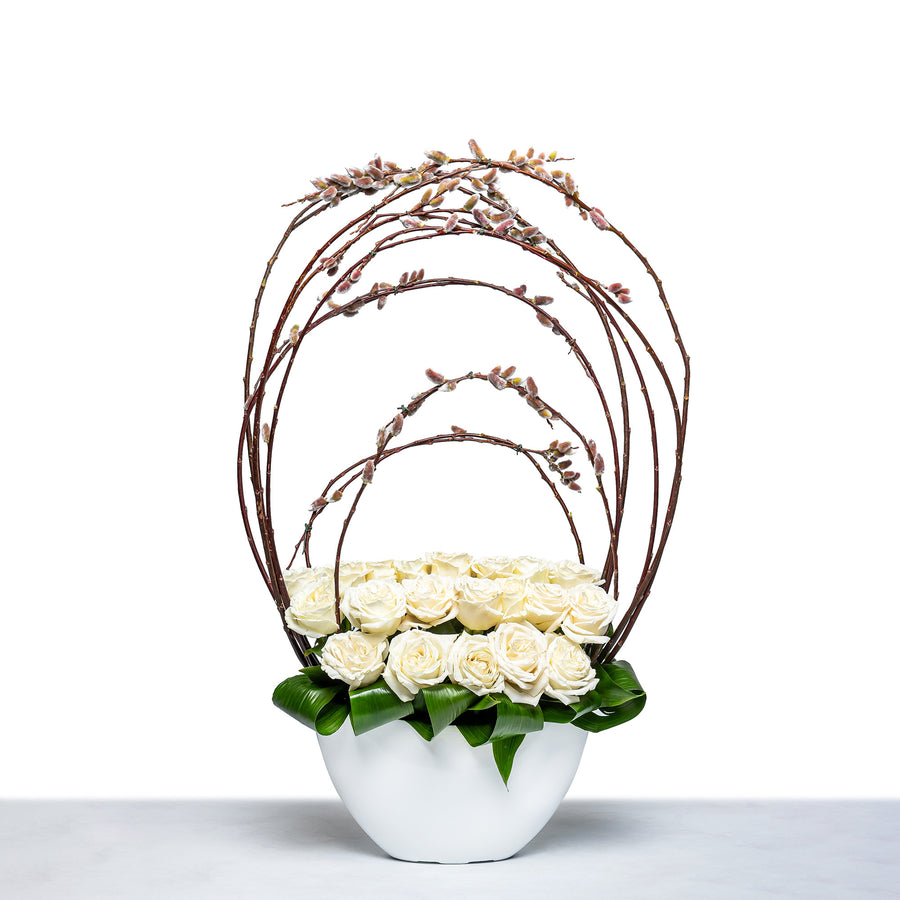 Sculpted Willow arrangement of white roses within a curved willow frame in a white bowl