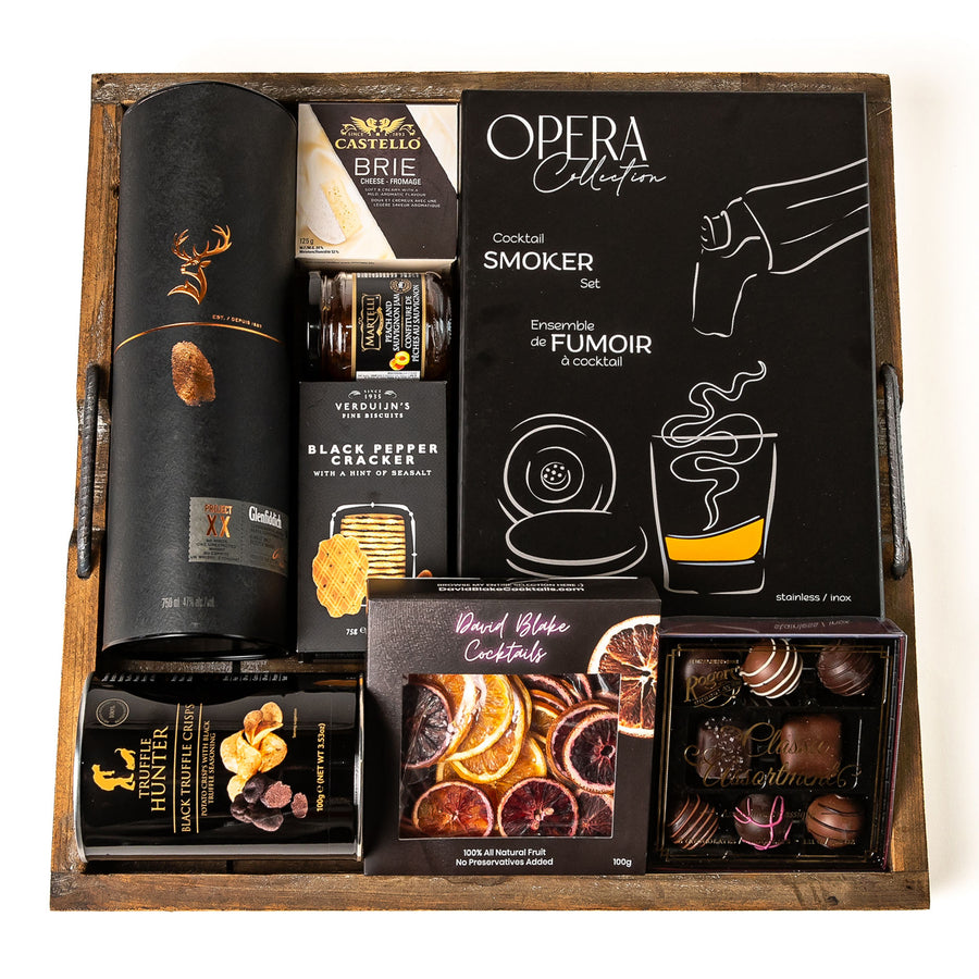 Smoked & Savoured: a square rustic wooden tray with Glenfiddich single malt whisky, an Opera cocktail smoker set, dried citrus slices, Castello brie, black pepper crackers, truffle crisps and a Rogers truffle box