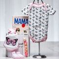 Soar baby girl gift with a butterfly print onesie, the book Mama by Jimmy Fallon and pink shoes