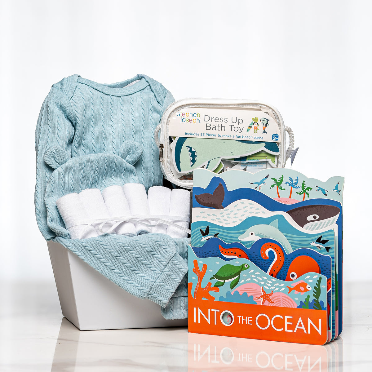 Splish Splash baby boy gift with a blue knitted set, bath toys and the book Into the Ocean