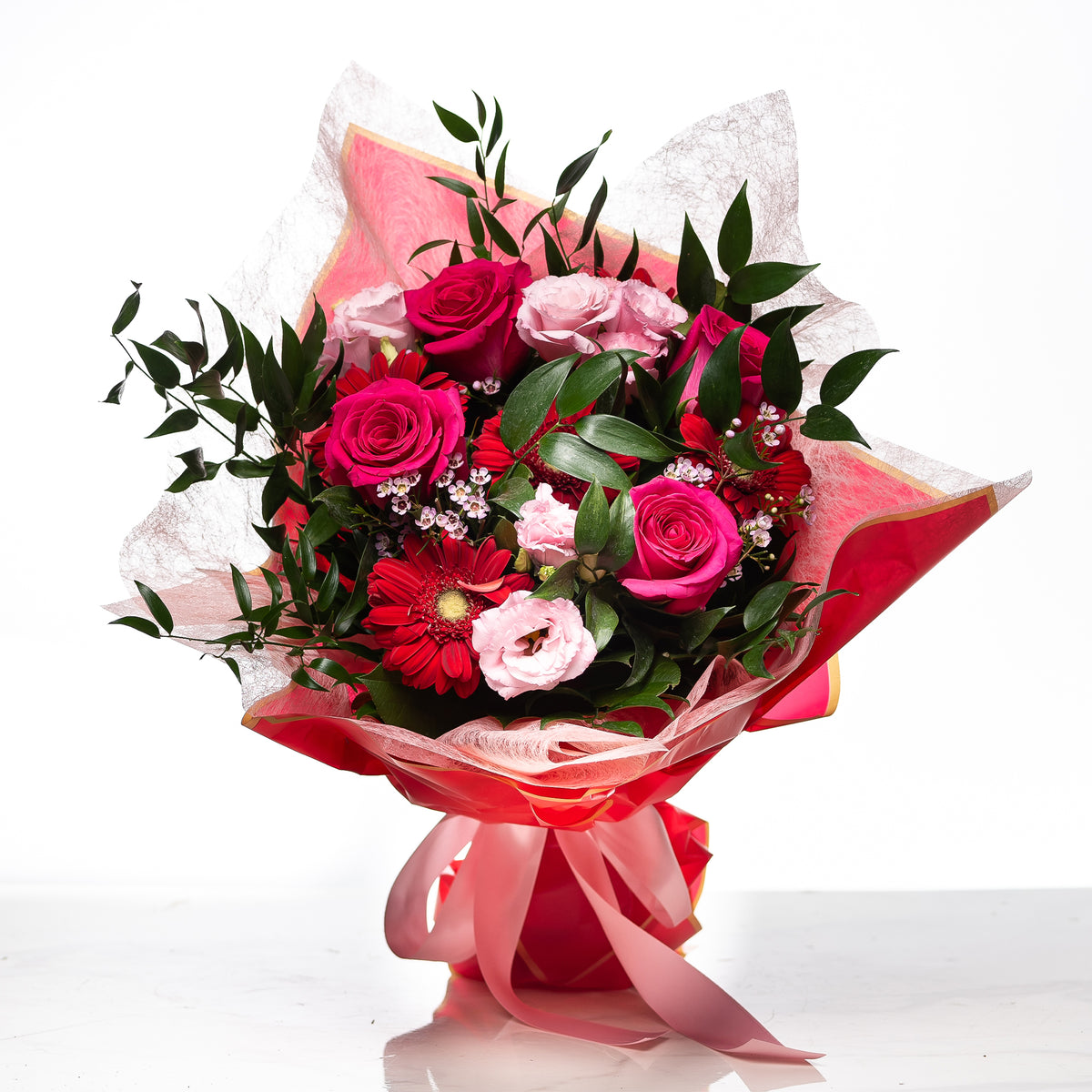 Sweet Heart bouquet of pink and magenta roses wrapped in pink paper and tied with a ribbon