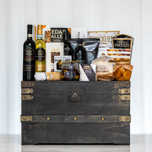 Treasure Trove large dark trunk with two bottles of wine, olive oil, crackers and pretzels