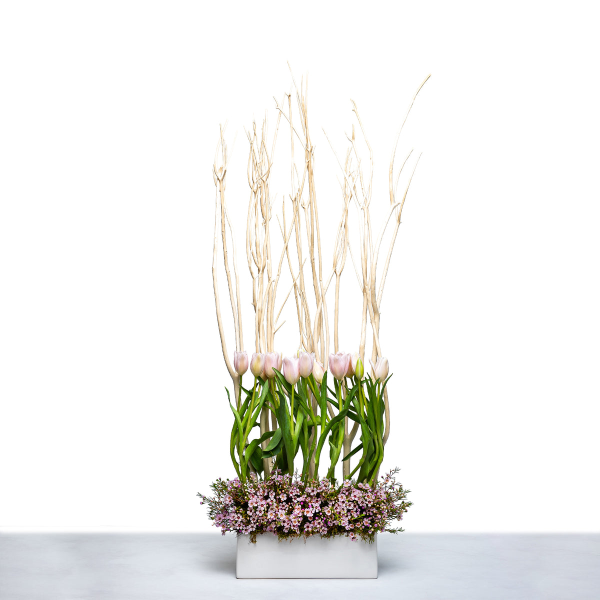 Tulip Garden arrangement of pink tulips with tall grasses and blossom in a white trough