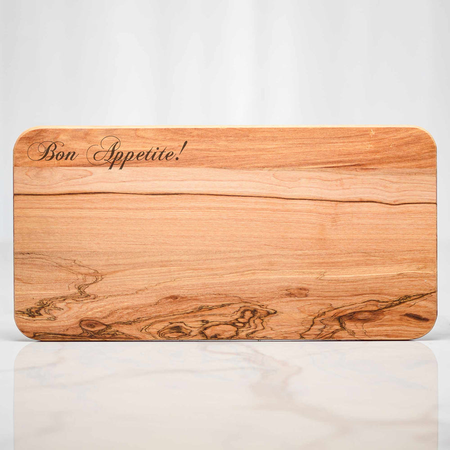 Olive wood footed serving board engraved with Bon Appetite