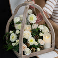 Winter Glow arrangement of white roses and blooms with pillar candles in a wooden lantern crate