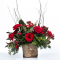 Winter Rosewood holiday centrepiece of red roses, berries and evergreen in a birch bark pot