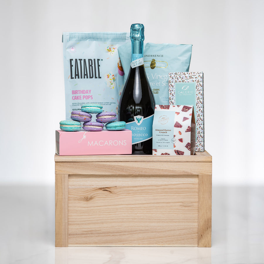 Birthday Bliss gift with sparkling wine, macarons, Eatable popcorn and birthday treats on a wooden riser
