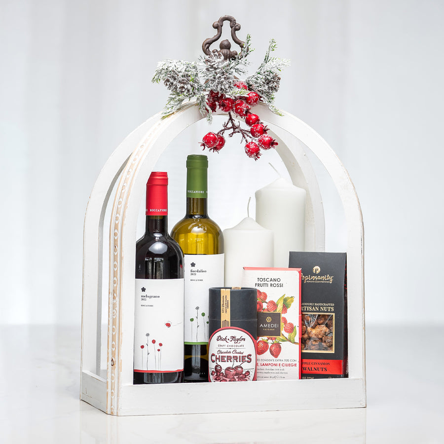 Evergreen Essence holiday gift arch with red and white wine, a candle and chocolates