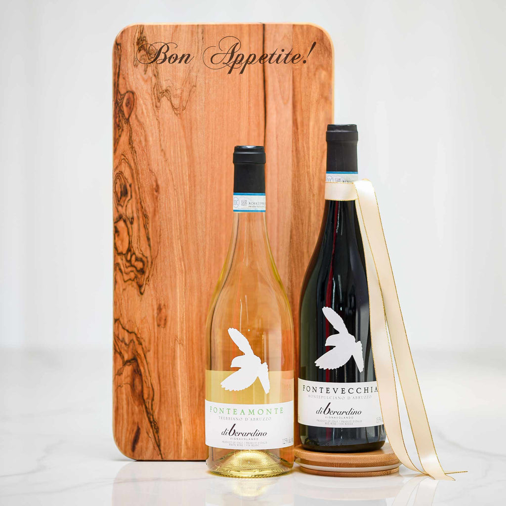 Footed Board Deluxe gift, an engraved olive wood serving board with a bottle of white and a bottle of red wine