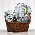 Hydrangea Haven gardening gift basket with blue hydrangea-patterned tool set, kneeling pad, gloves, glass plant mister and a herb growing kit in a lined wicker basket
