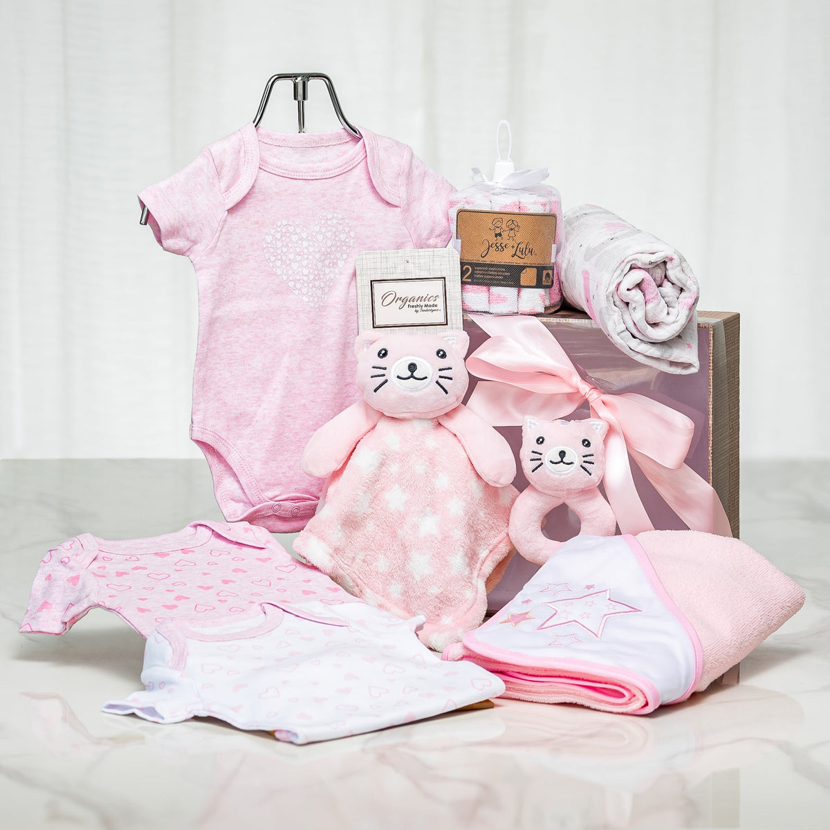Little Star baby girl gift with pink onesies, a blanket and a plush kitten in a wooden crate