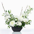 Posh arrangement of white roses, carnations and orchids in a black footed bowl